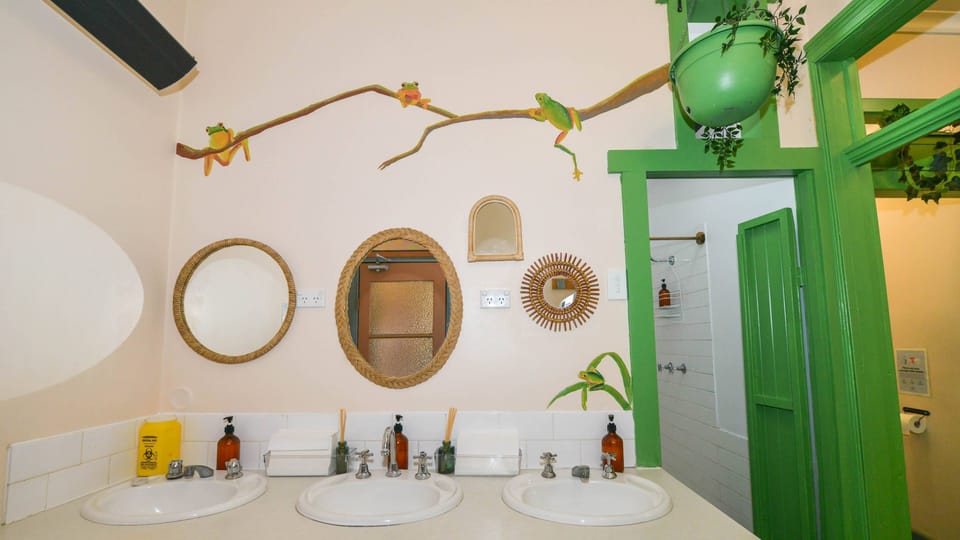Large share bathroom. Three separate sinks to individual cublicles for showers/toilets. 