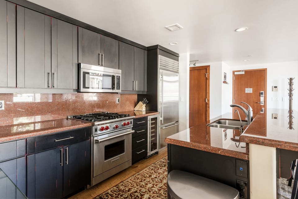 Fully equipped kitchen featuring bottom freezer stainless steel fridge, dedicated wine fridge, wolf gas range