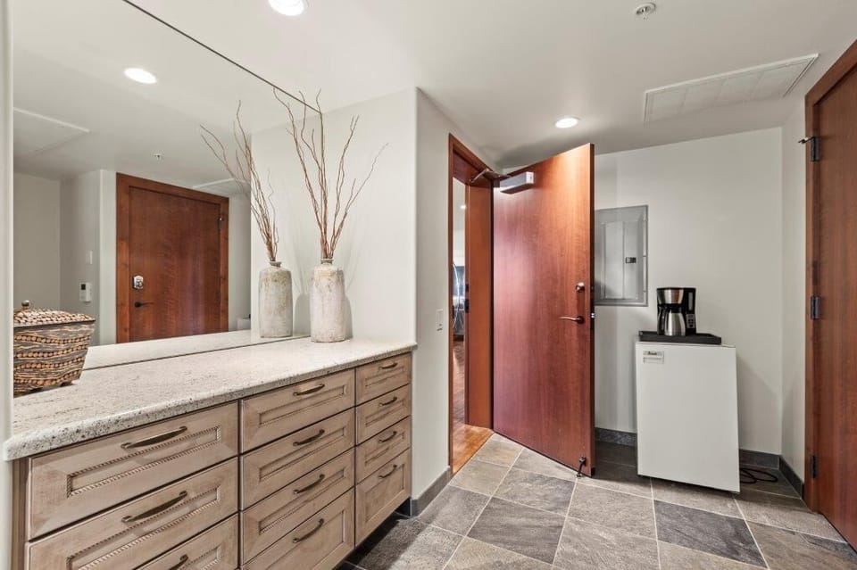 The entryway with built in cabinets, mini fridge and coffee pot.
