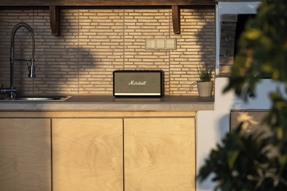 A well-equipped outdoor kitchen featuring a speaker awaits you.