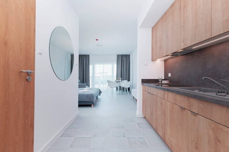 A closer view of a kitchen space featuring wooden cabinets, a sink, and a minimalist design.