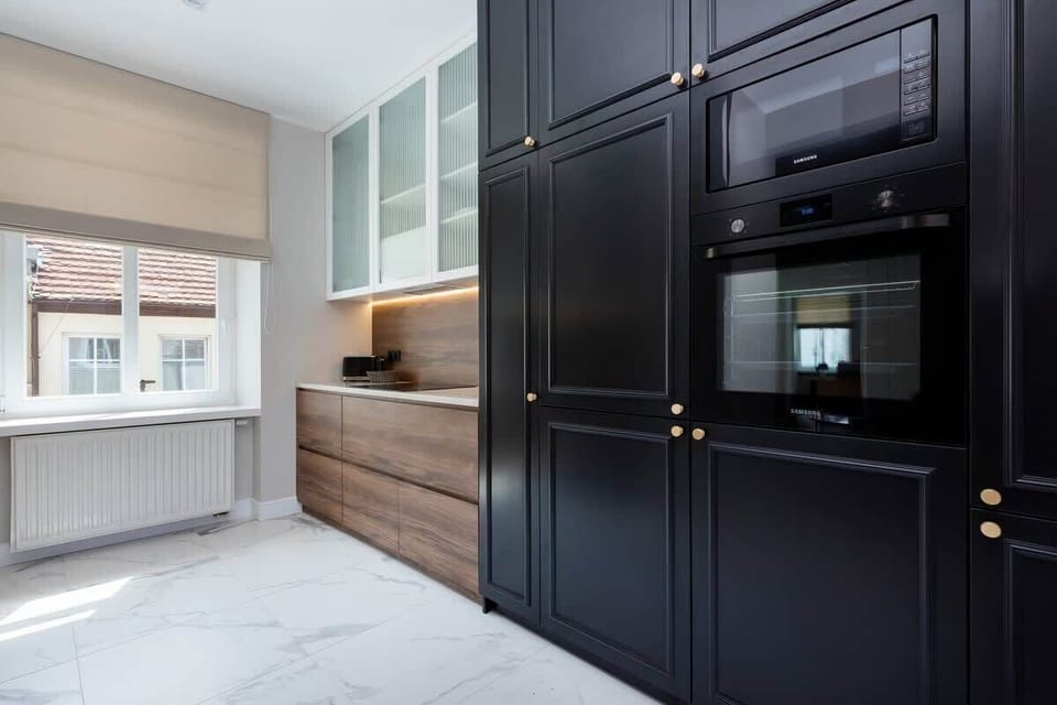 A sleek, modern kitchen with dark cabinets and wooden countertops. The space is clean and stylish.