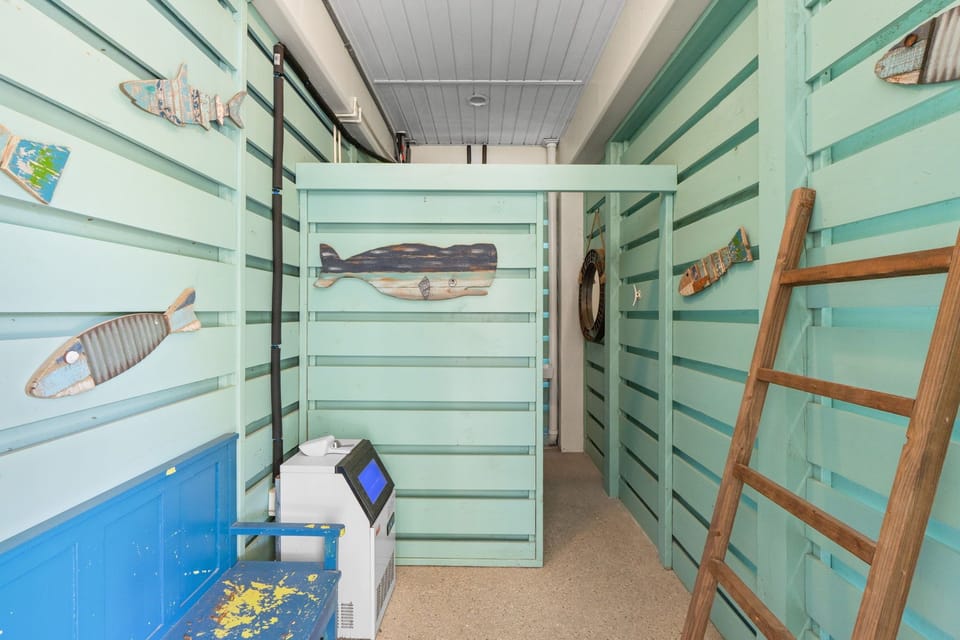 Step into your nautical-themed bunk room where ocean adventures come alive with whale artwork and sea-green walls.