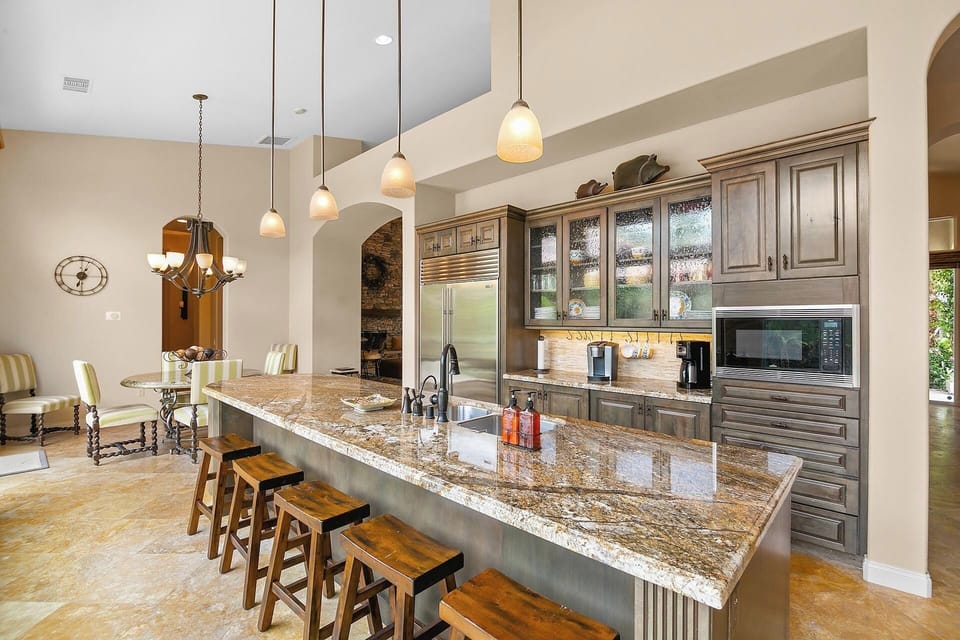Granite countertops, Wolf 6 burner gas range, high-end appliances, and a spacious island with seating for 5