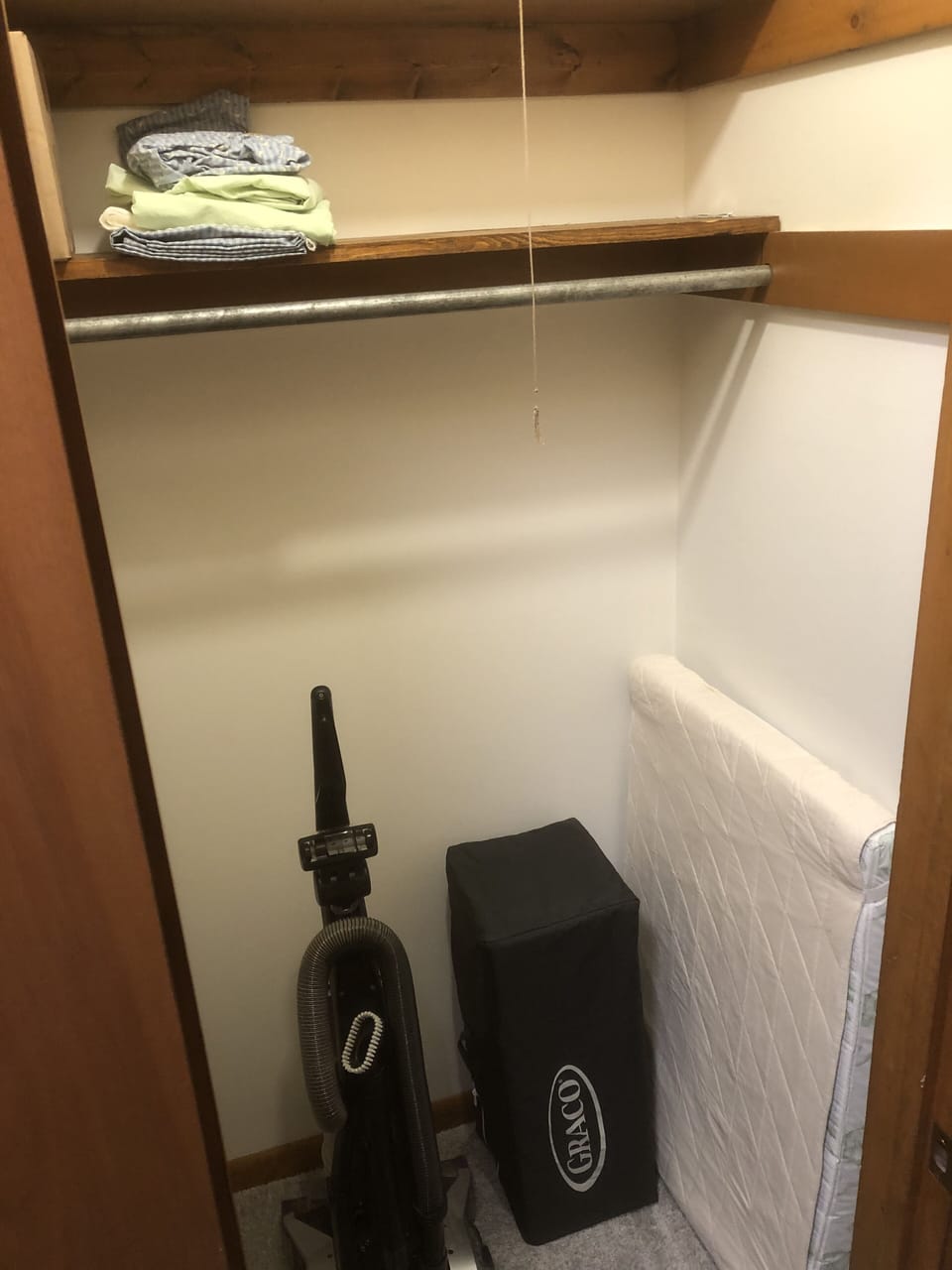 The entry hall closet has a pack-n-play with mattress, bedding and high chair