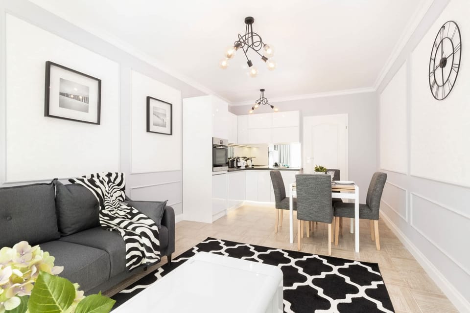 The living room from a different angle, showing its elegant black-and-white patterned decor and access to the dining area.