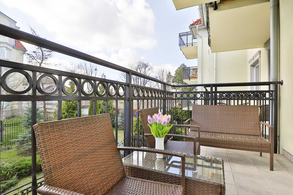 A private balcony featuring outdoor seating with a chair and a small table, offering views of the surrounding area.