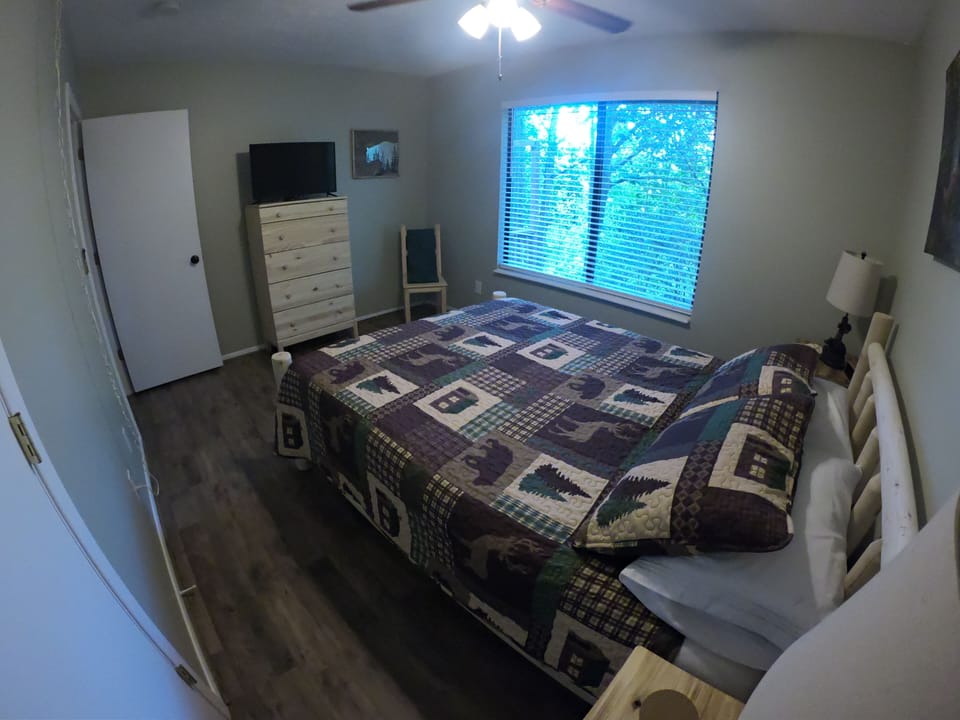 bear bedroom with queen bed and TV