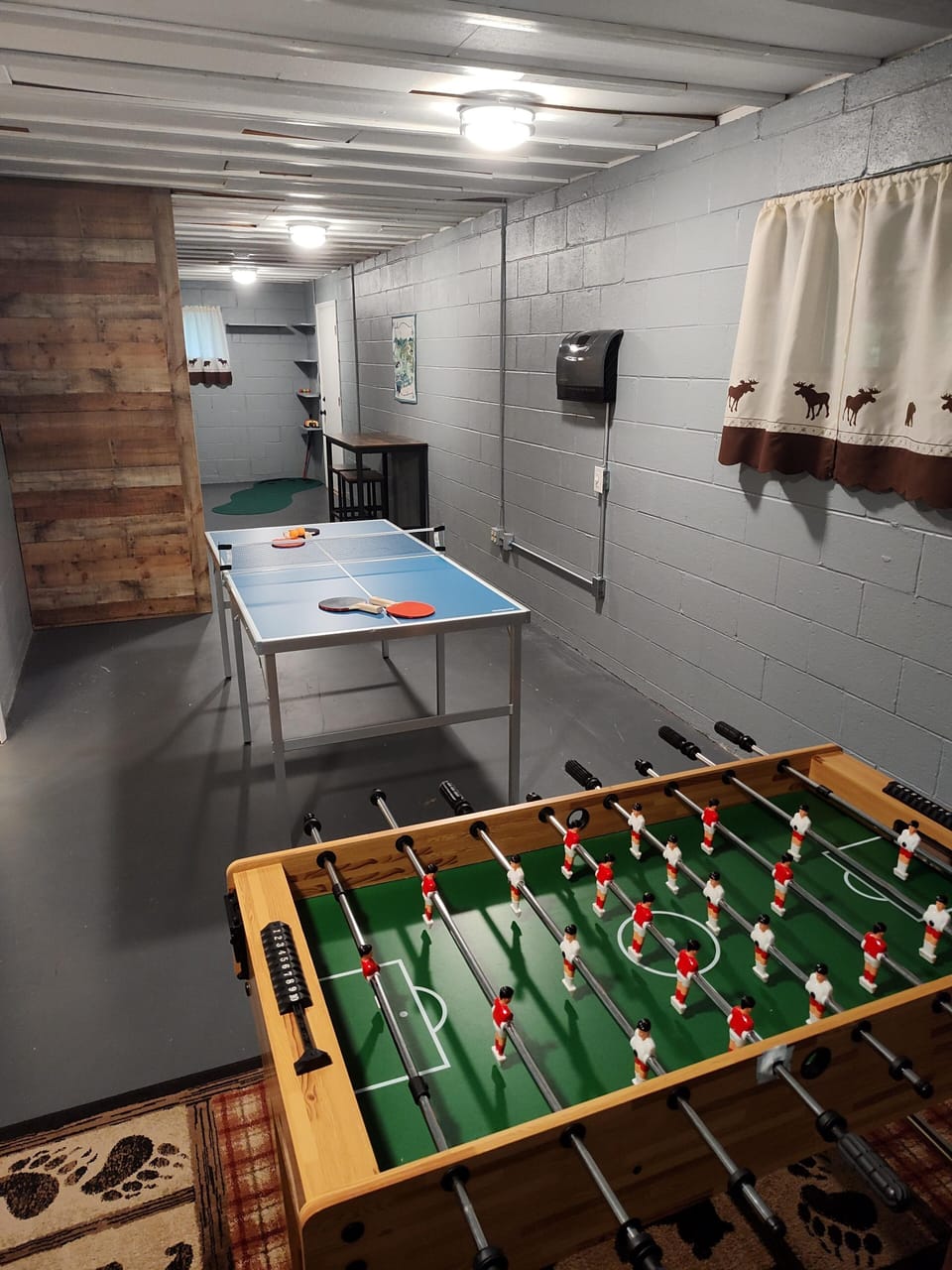 lower level with foosball, ping pong, and a golf putting green