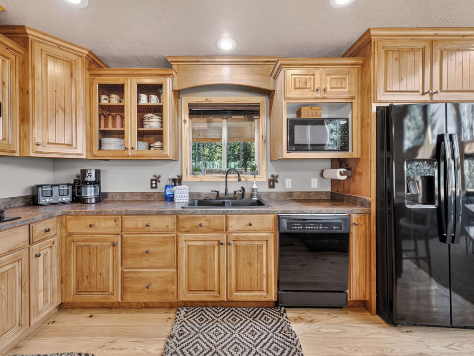 Your fully equipped kitchen features warm wood cabinetry, granite counters, modern stainless appliances, and plenty of space to prepare memorable meals during your stay.