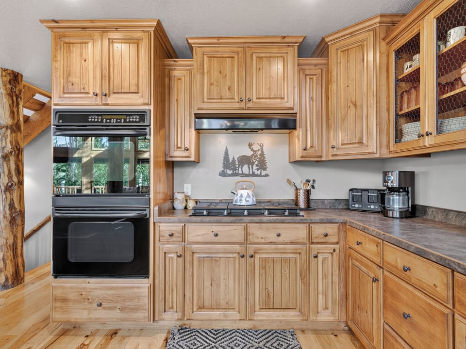 Your rustic kitchen features natural wood cabinetry, modern appliances, and charming wilderness decor. Brew your morning coffee with the mountain air as your backdrop—pure cabin magic.