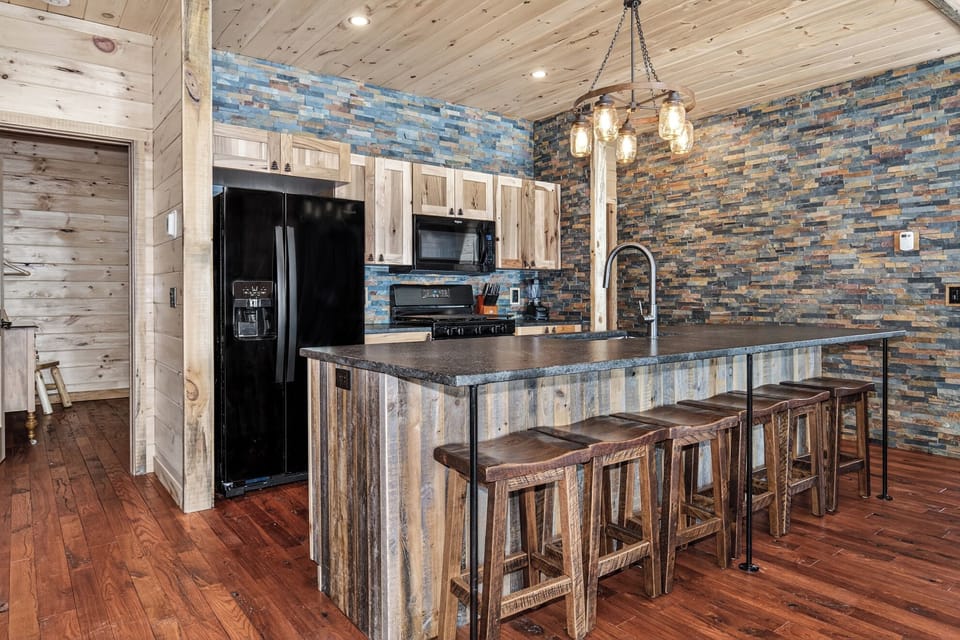 Rustic kitchen blends stone accents and reclaimed wood with modern appliances for your perfect Northwoods getaway cooking experience.