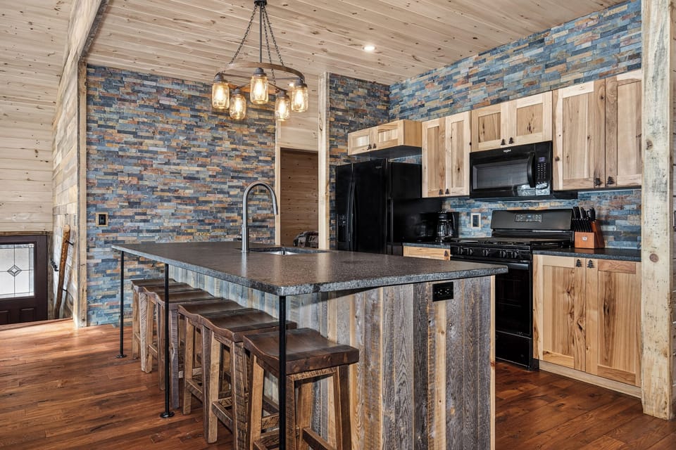 Your rustic-chic kitchen blends natural wood and stone textures, where you'll craft meals under warm pendant lighting and gather around the stunning island.