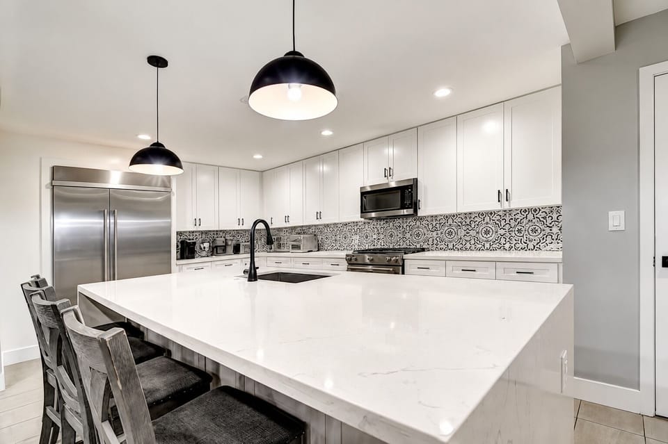 Spacious modern kitchen with huge quartz waterfall island.
