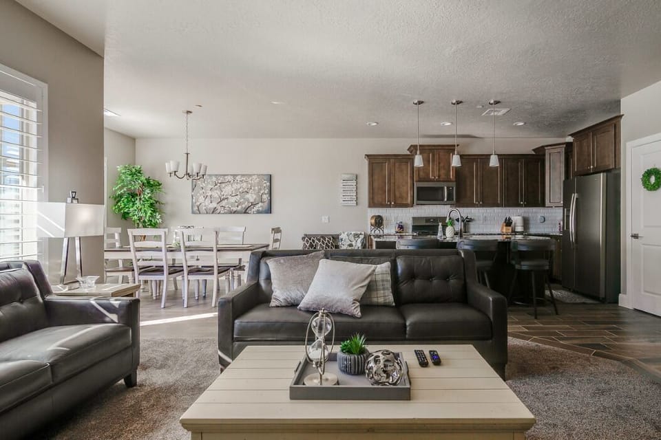 Roomy great room with well equipped kitchen, dining space, sofas and large TV.