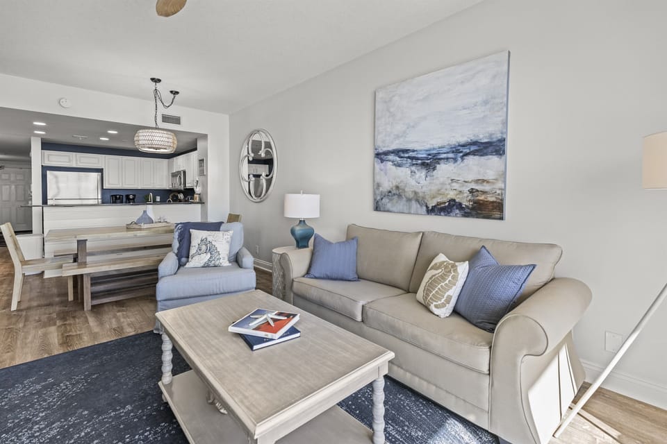Sink into your comfortable sofa while the coastal-inspired artwork and soothing blue accents create the perfect retreat atmosphere.