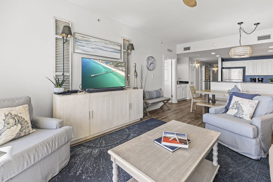Unwind in your stylish coastal living space with plush seating, ocean-themed accents, and an open layout that flows into the modern kitchen.