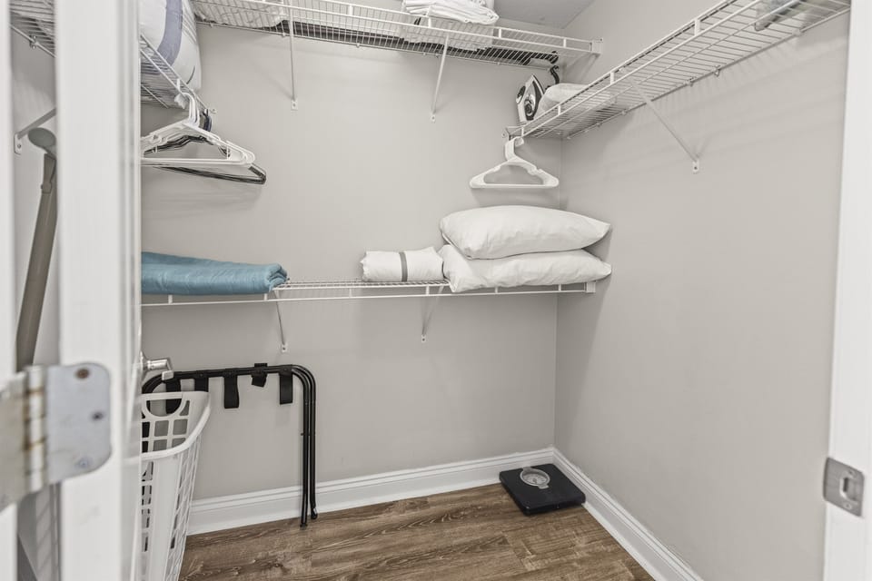 Your spacious walk-in closet offers ample storage with wire shelving, hanging space, and fresh linens waiting for your arrival.