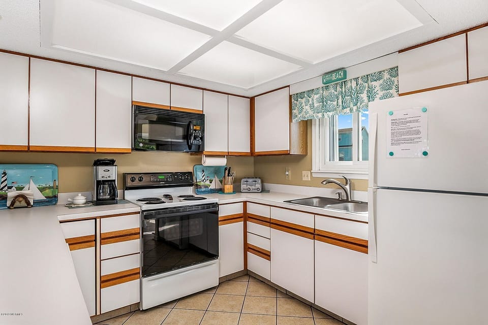 A kitchen that features a dishwasher, microwave, toaster, coffeemaker, and more