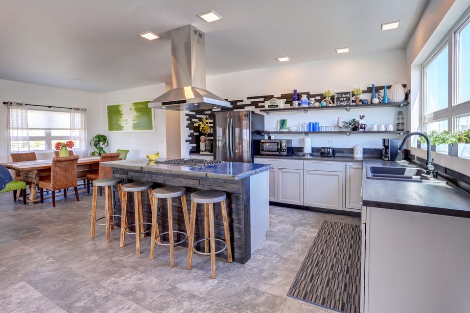 Open kitchen design with gas range and bar-like seating.