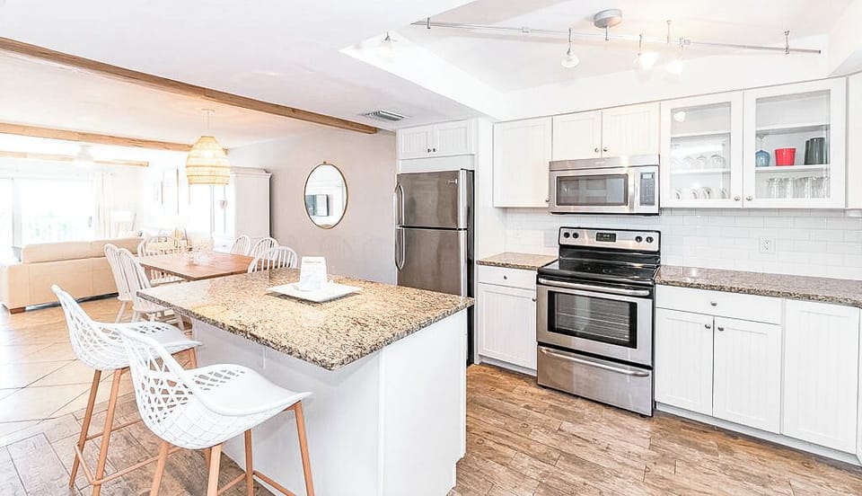 A renovated kitchen with an island and sleek stainless steel appliances