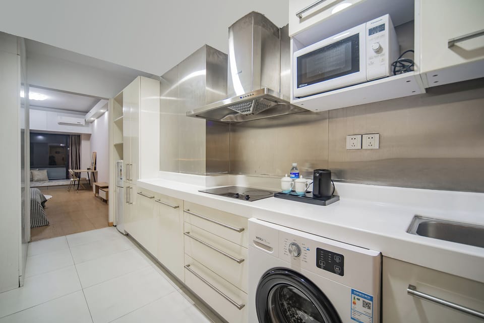 Full-size fridge, microwave, cleaning supplies, paper towels