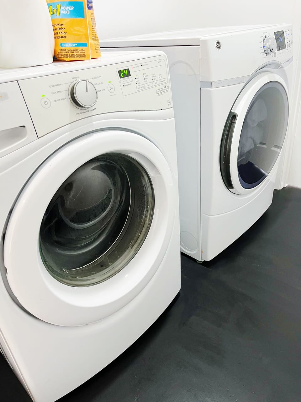 Laundry room has an iron/ironing board, and laundry detergent and dryer sheets.
