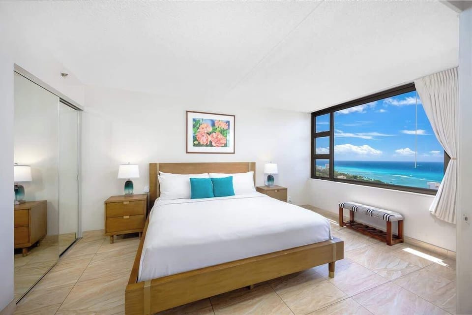 Sun-filled bedroom w/ teal accents & a bed ready to melt your travel fatigue away.
