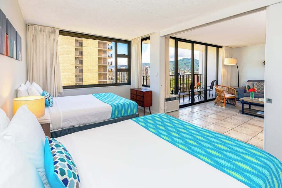 Bright room with two beds and a balcony offering mountain views