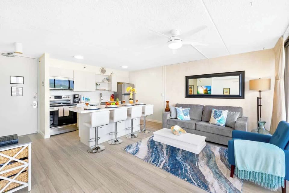 Living room has a a ceiling fan, queen-size pullout sleeper sofa, coffee table, chair, window AC, and a flat screen TV!