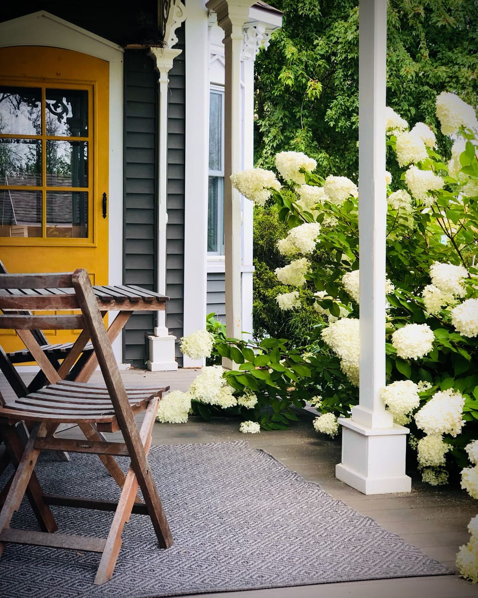 A cozy porch nook perfect for private convos, sips of coffee or a glass of wine!