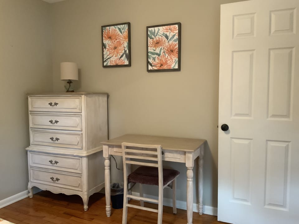 Desk and dresser is room with queen bed