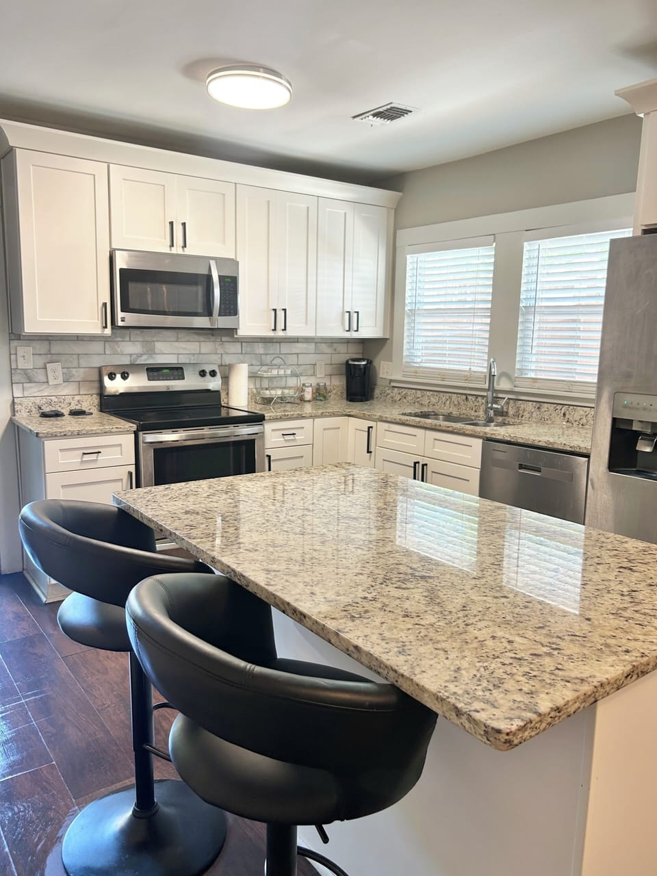 Modern kitchen: granite countertops, SS appliances and marble backsplash.