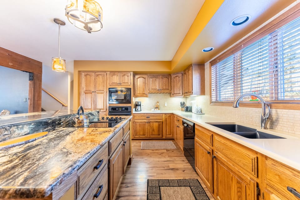 Your fully equipped kitchen features granite countertops, oak cabinetry, and modern appliances perfect for preparing memorable meals together.