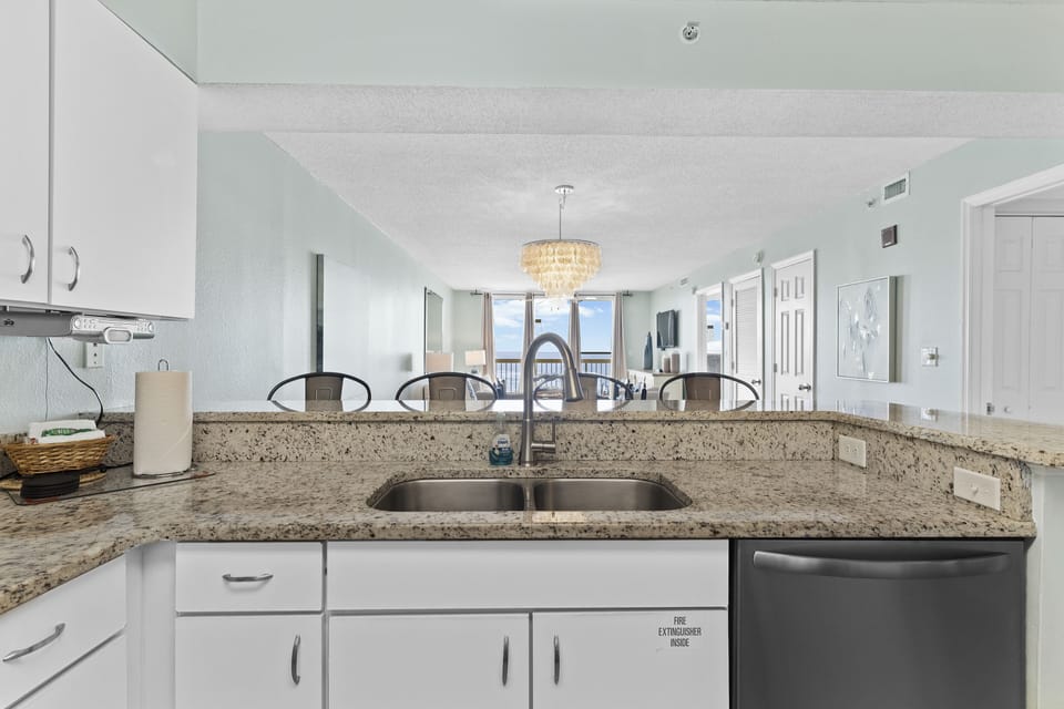 Kitchen features stainless appliances, granite, cookware, dishes, and glassware