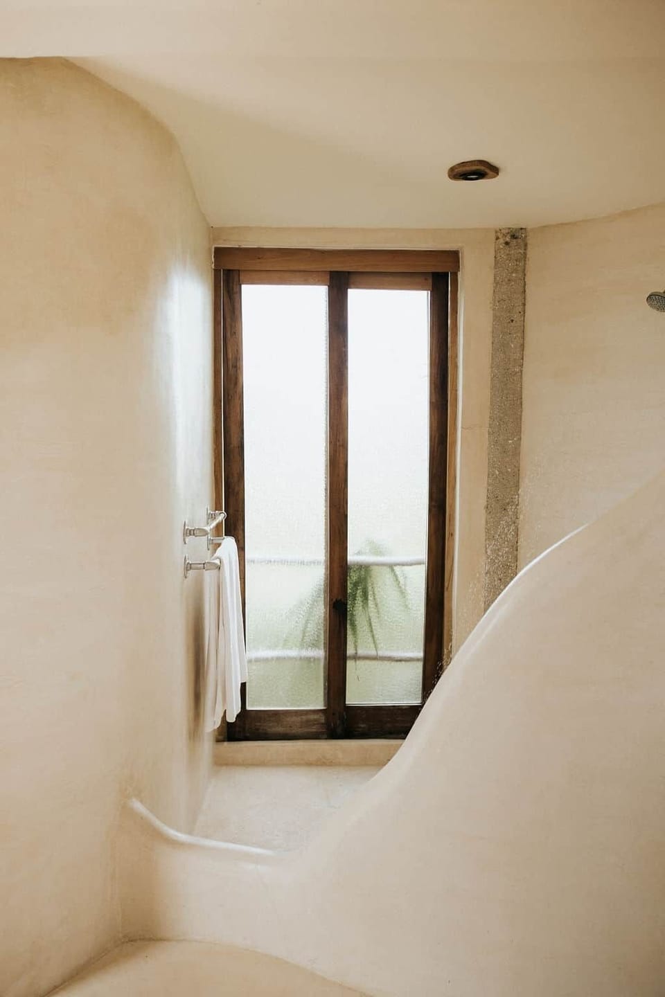 Shower in master bathroom with fresh linens