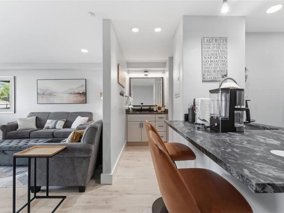 Sink into the plush sectional sofa and enjoy your morning coffee at the sleek breakfast bar, perfectly positioned for conversation and relaxation in your modern open-concept space.