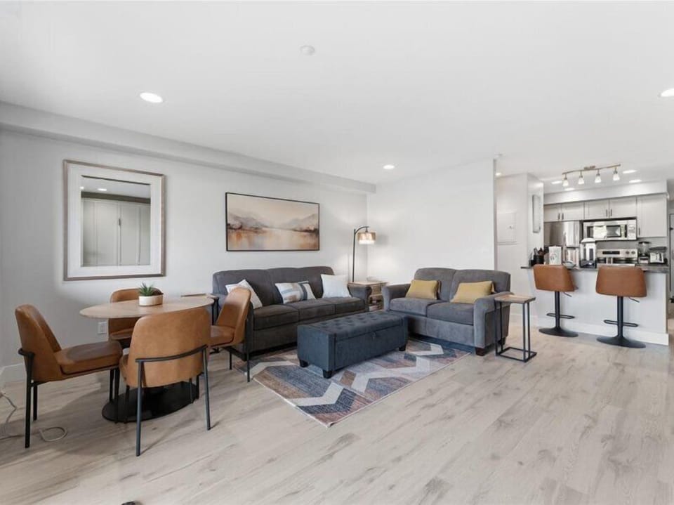 Picture yourself relaxing in this bright, open living space where modern comfort meets thoughtful design. Plush seating invites you to unwind, while the open layout flows seamlessly into your fully equipped kitchen—perfect for your morning coffee or evenin