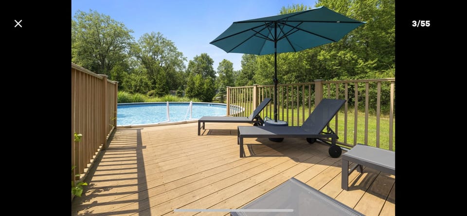 Huge 30 ' round pool, 4 loungers, and umbrella