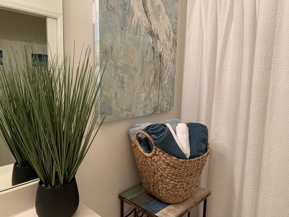 Ensuite bathroom from the guest room with bathtub and shower with new linens.