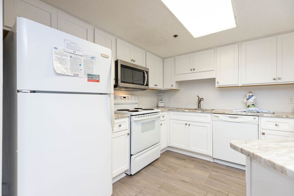 Prepare meals in this bright kitchen featuring white appliances and ample counter space
