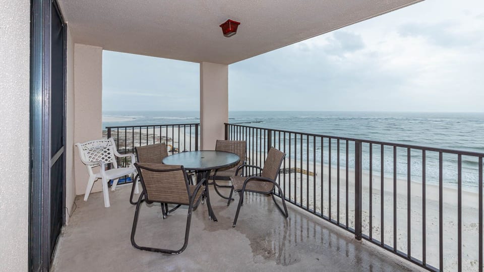 Enjoy meals or drinks at the round table on the balcony, with expansive views of the water and gentle waves