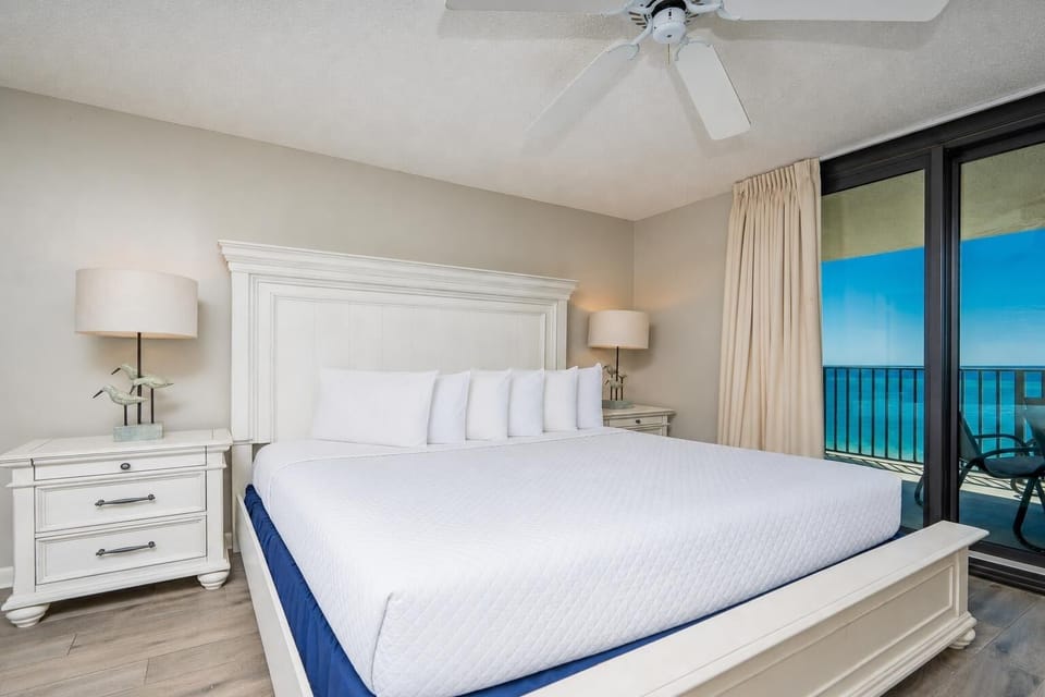 Unwind in the spacious master bedroom with a king bed, soft lighting, and beachfront balcony access