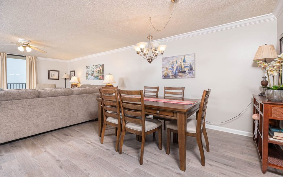 Enjoy meals at the wooden dining table, surrounded by artwork and soft lighting for a welcoming atmosphere