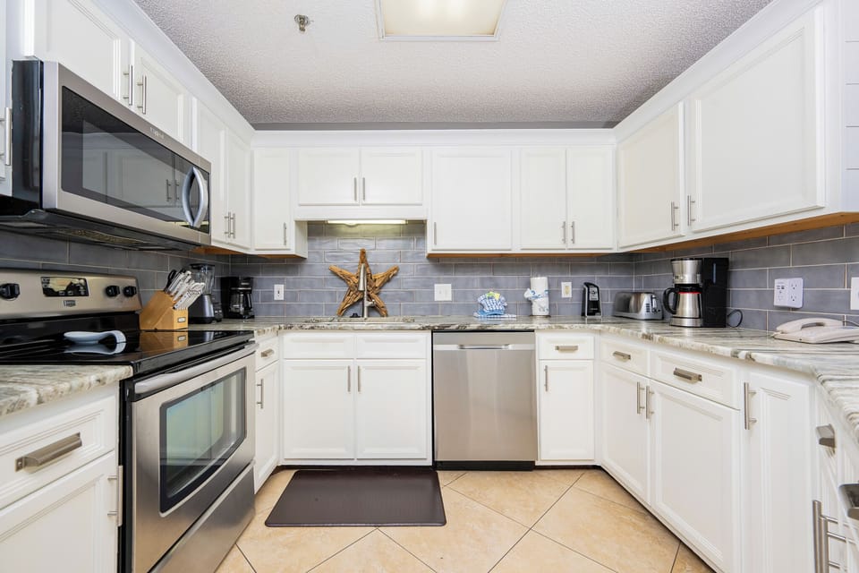 Bright white cabinetry and stylish countertops create a welcoming atmosphere in this modern kitchen with a breakfast bar