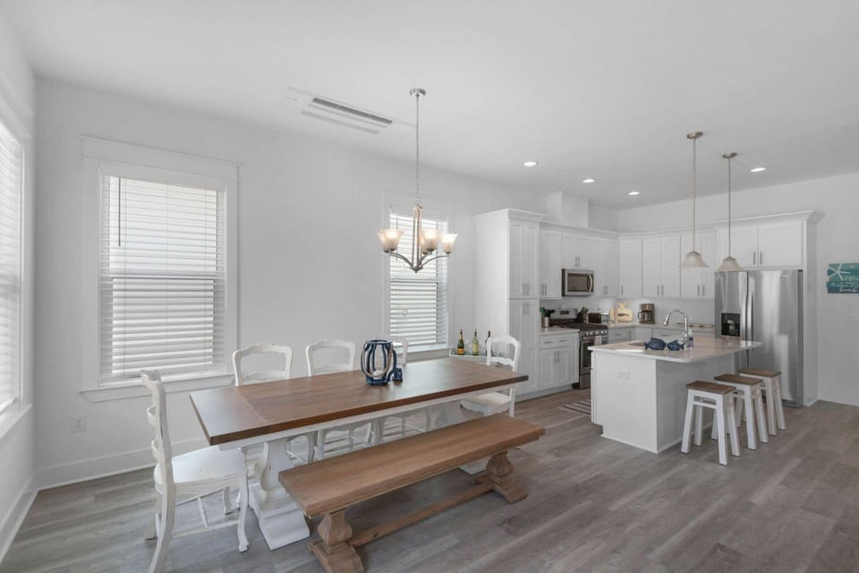 The farm style dining table has seating for up to 8 guests, and there are also an additional 3 seats at the kitchen island.