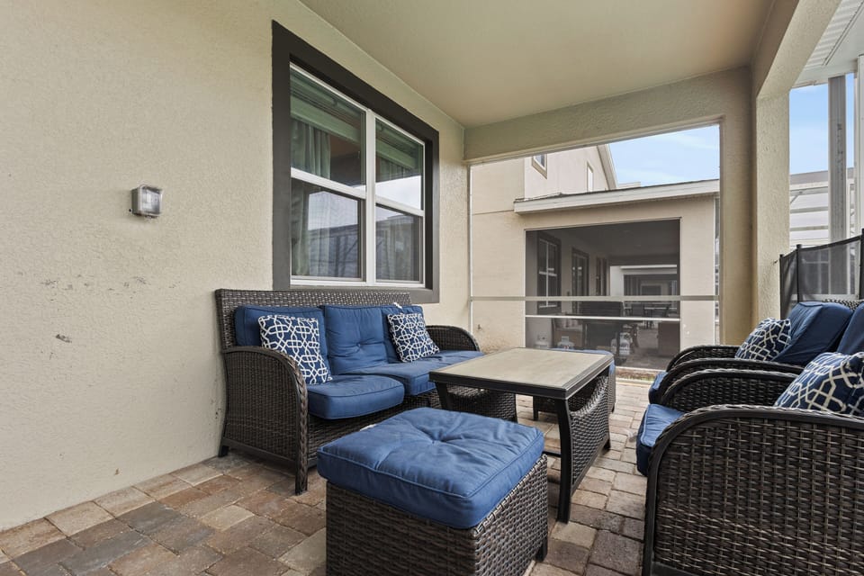 Unwind on your private patio with plush navy seating and stylish wicker furniture, perfect for morning coffee or evening relaxation.