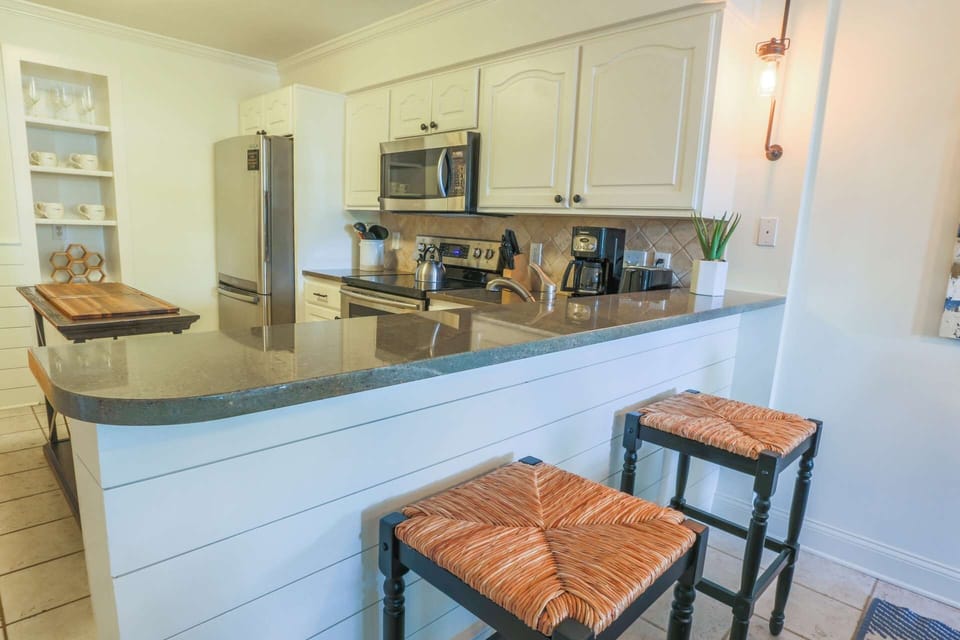 The kitchen features stainless steel appliances and beautiful countertops.