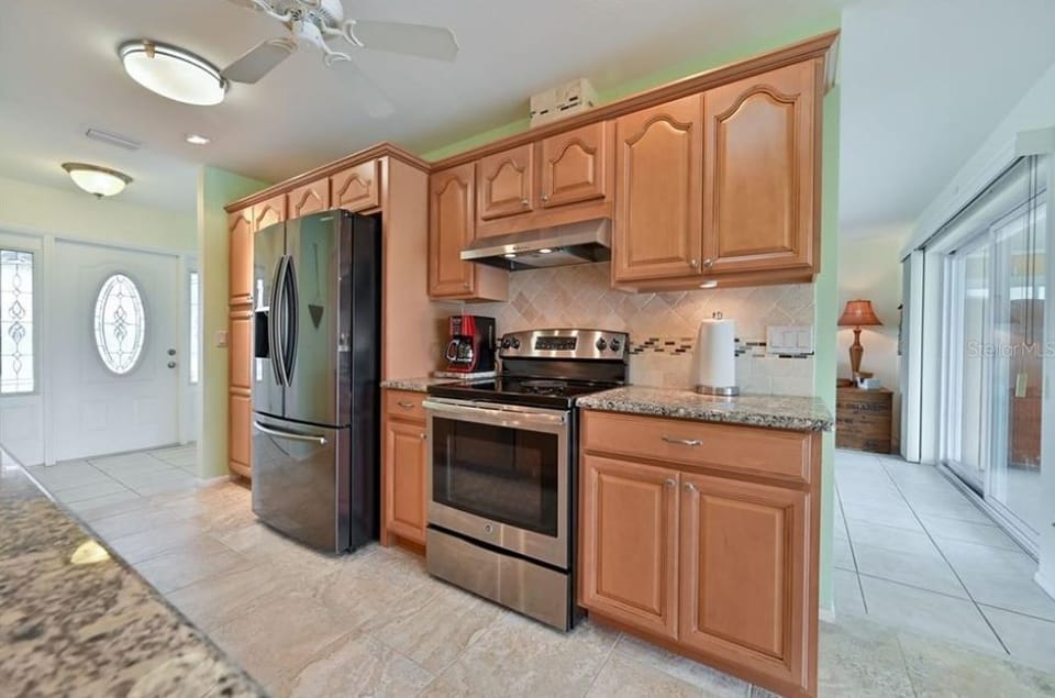 Fully stocked kitchen with granite counter tops and stainless steel appliances.