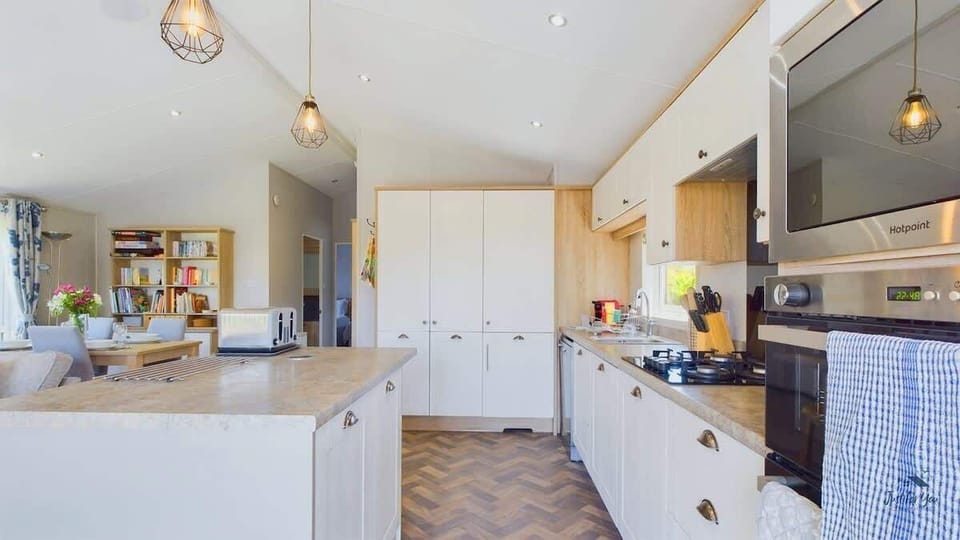 Bright kitchen and dining area at Poppy Lodge with dining table for meals and modern kitchen appliances.

